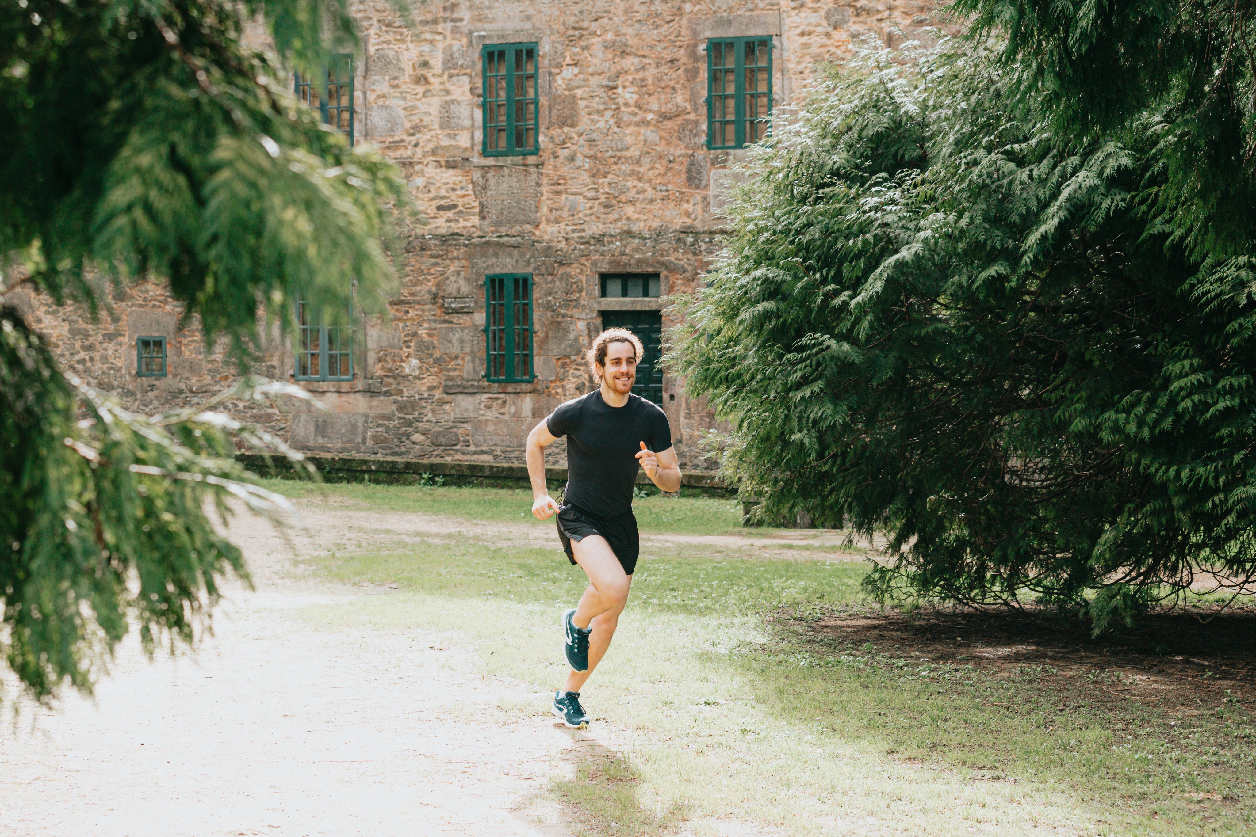 man-runs-outdoors-with-a-stone-building-behind-him.jpg